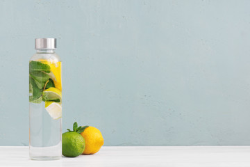 Water with lemon and mint in the transparent glass bottle