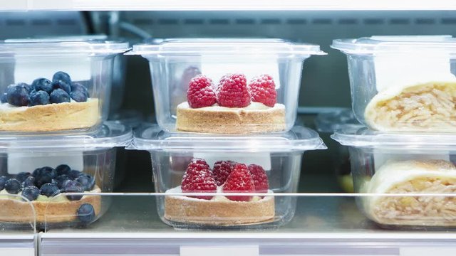Small raspberry cake for dessert eating.Delicious little cake in refrigitator packed in plastic container.Fresh sweet pastry for coffee break.