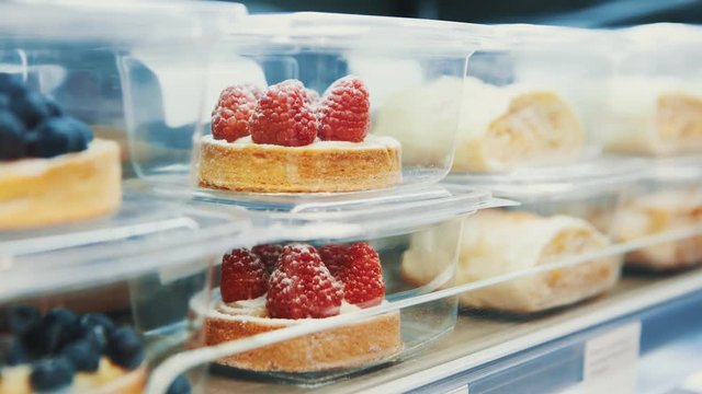 Small raspberry cake for dessert eating.Delicious little cake in refrigitator packed in plastic container.Fresh sweet pastry for coffee break.