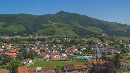 Naklejka na ściany i meble Town of Saint-Jean-Pied-de-Port under hills and blue sky in the Basque Country of France