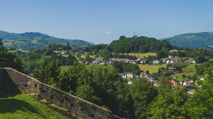 Fototapeta na wymiar Town of Saint-Jean-Pied-de-Port under hills and blue sky in the Basque Country of France