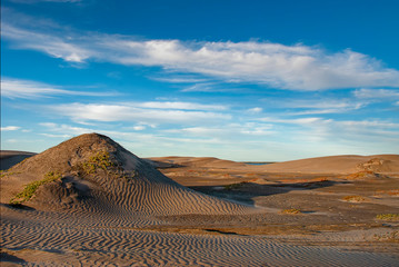 The late afternoon sun casts shadows across the sand dunes at Adolfo Lopez Mateos in Baja California, Mexico
