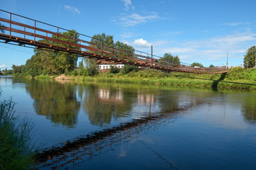 Suspension bridge over the river Msta on a summer day. City Borovichi, Russia