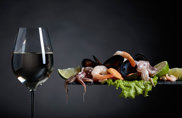 Glass of white wine and mixed delicious seafood.