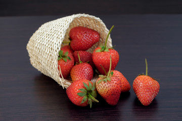 Group of Strawberries in basket on wood background.