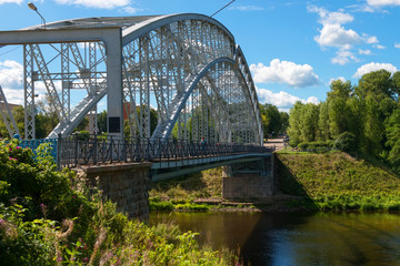 Borovichi, Russia - August 8, 2018: First in Russia steel arch bridge on river Msta in sunny summer day. Novgorod region, Borovichi, Russia. Was built in 1905.