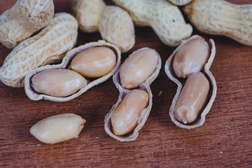 Peanuts in shells on wood table background.