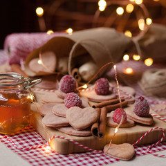 Composition for Saint Valentine's day: pink biscuits in the shape of heart, decorated with frozen raspberries -perfect surprise for beloved