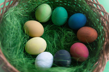 Kolorowe jajka leżące w koszyczku. 