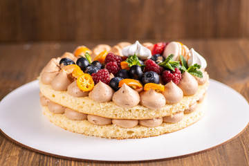Fresh delicious homemade cake with berries on wooden table
