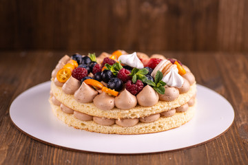 Fresh delicious homemade cake with berries on wooden table