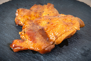 Chicken in teriyaki sauce black slate plate. Asian cuisine - Japanese, Chinese, Korean.