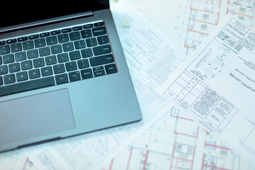Pencil and computer laptop on architectural drawing paper for construction