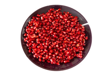 red ripe pomegranate seeds on a brown plate close-up. pomegranate fruit. healthy diet.