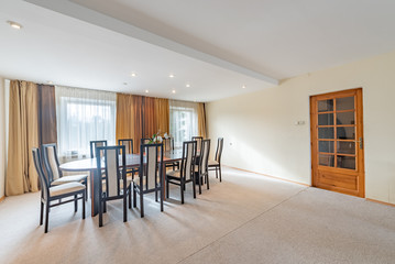 Living room with two windows and table, chairs.