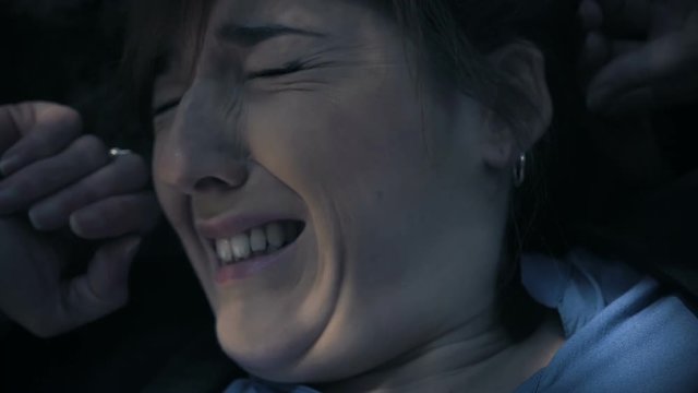 violence against women. Young terrified woman screamig in the dark