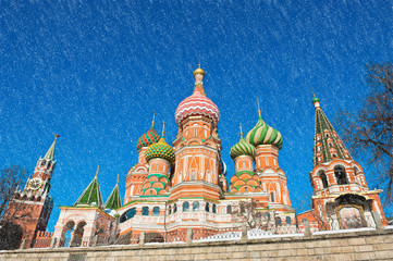 The Cathedral of Vasily the Blessed (Saint Basil's Cathedral) and the Spasskaya Tower of Moscow Kremlin.  Winter day. Snowfall. Red Square. Russia