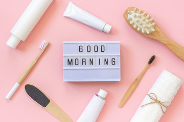 Light box text Good morning and set of cosmetics products and tools for shower or bath on pink background. Concept female morning body care, face, teeth for beauty and health. Template Top view