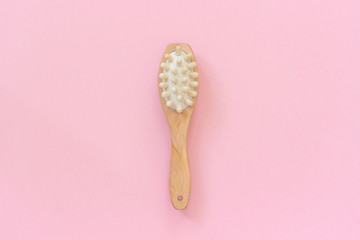 Brush for massage, peeling and body care on pink paper background. Concept of beautiful, healthy body and fight against cellulite. Template Copy space Top view