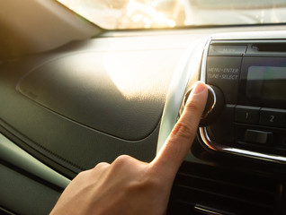 Finger press on a car audio menu button