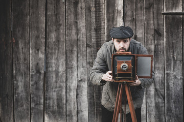 Photographer prepares for shooting on large format camera. Concept - photography of the 1930s-1950s - Powered by Adobe