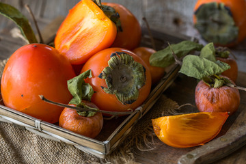 Fresh ripe persimmons on wooden background. Food background.