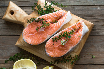 Salmon fish. Uncooked salmon fillet with ingredients for cooking - fresh lemon and spices on Wooden. Top view with copy space.