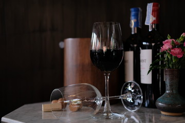 Glass of red wine and bottle of wine on wooden table