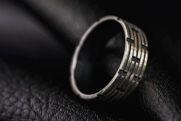 Male ring on a stand made of black leather with copy space
