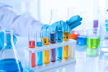 scientist with equipment and science experiments, laboratory glassware containing chemical liquid for research or analyzing a sample into test tube in laboratory