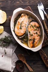 Grilled fish, grilled salmon steak with addition of lemon,  and spices on grill bowl, close-up.