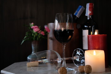 glass of red wine and bottle of wine on wooden table