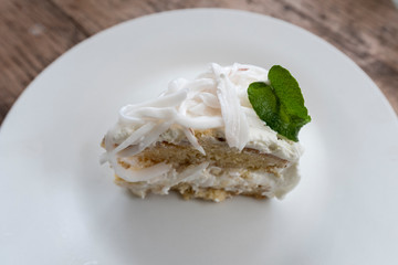 Coconut cream cake on a white plate with whipped cream and decorated