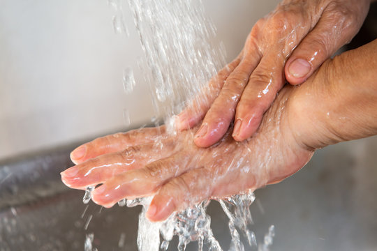 Senior woman washing her hands, Flowing and  Splashing water, Close up & Macro shot, Selective focus, Healthcare concept