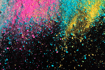 An explosion of colorful pigment powder on black background. Vibrant color dust particles textured...