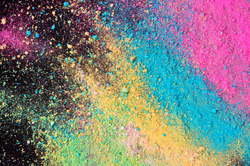 An explosion of colorful pigment powder on black background. Vibrant color dust particles textured background.
