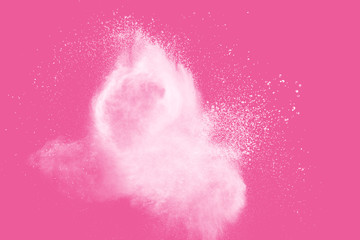 White powder explosion on pink background.White dust particle splashing.