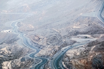Geological landscape of Jabal Jais characterised by dry and rocky mountains, Road between mountains in Ras Al Khaimah, United Arab Emirates