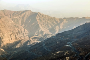 Geological landscape of Jabal Jais characterised by dry and rocky mountains, Road between mountains in Ras Al Khaimah, United Arab Emirates