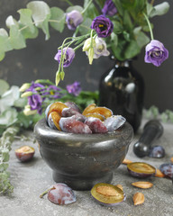 halves of fresh plums and plum pits. Harvest plums. Fruit cake ingredients