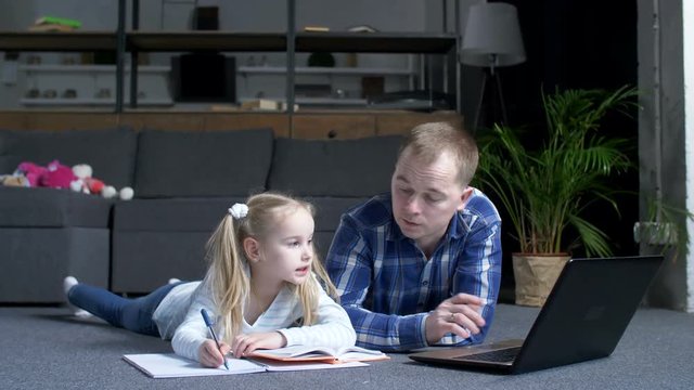 Advanced father with laptop searching online explanations to educational material for little daughter during home schooling. Caring father with preadolescent girl studying online course using latop pc