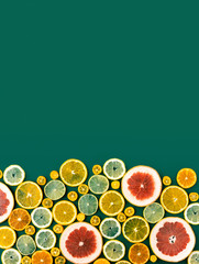 Juicy fresh bright summer green vertical background with citrus fruits, flat lay. Sliced mixed citrus fruits, concept of healthy eating, detox, dieting, top view and flatlay.