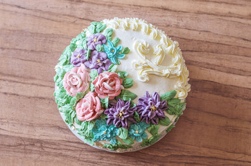 Tasty big cake decoreted with cream roses close-up