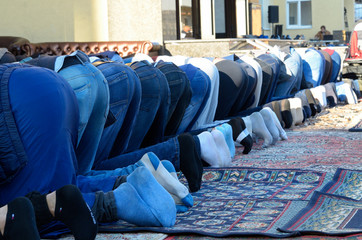 Men (muslims) bending down and praying