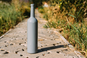 one gray bottle on the road from the tiles, the village, rural alcoholism, drunkenness. alcoholic...