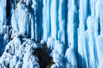 Large icicles hang from river bank cliff.