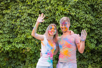 Festival of holi, friendship - young people playing with colors at the festival of holi