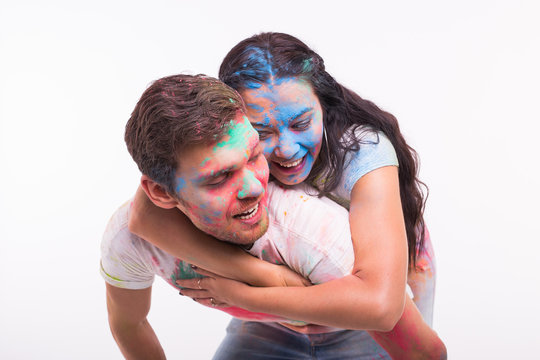 Festival of holi, friendship - young people playing with colors at the festival of holi on white background