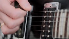 Hands of male playing at electric guitar. Plays solo of rock. Slow motion
