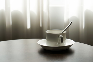 Fototapeta na wymiar white tea cup coffee cup on the table by a sofa couch in hotel room, kettle